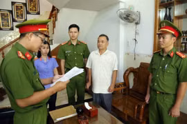 Cán bộ điều tra tống đạt quyết định khởi tố, thi hành lệnh bắt Lê Tự Trị, Giám đốc Trung tâm đăng kiểm xe cơ giới 85-02D, ở nhà riêng tại phường Phú Lâm, thành phố Tuy Hòa, tỉnh Phú Yên. (Ảnh: TTXVN phát) 
