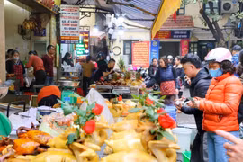 Đa dạng các loại gà cúng, từ luộc cho tới chiên, rán được bày bán ở các chợ. (Ảnh: Tuấn Đức/TTXVN) 