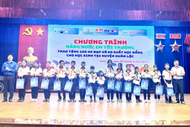Đoàn Thanh niên TTXVN khu vực phía Nam trao 50 suất học bổng cho các em học sinh có hoàn cảnh khó khăn vươn lên trong học tập tại huyện Xuân Lộc, Đồng Nai. (Ảnh: Lê Xuân/TTXVN)