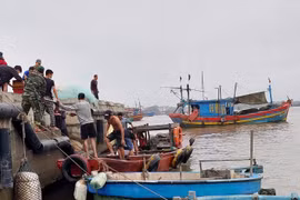 Lực lượng biên phòng và người dân tham gia hỗ trợ, ứng cứu tàu cá gặp nạn. (Ảnh: TTXVN phát)