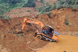 Các phương tiện máy móc tập trung xử lý hàng ngàn mét khối bùn đất trong vụ sạt lở. (Ảnh Đức Thọ/TTXVN)