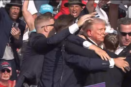 Cựu Tổng thống Donald Trump được mật vụ Mỹ hộ tống rời khỏi bục diễn thuyết trong cuộc vận động tranh cử ở thành phố Butler, bang Pennsylvania sau khi xảy ra vụ nổ súng. (Ảnh: THX/TTXVN)