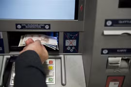 Người dân rút tiền tại cây rút tiền tự động (ATM) ở Berlin, Đức. (Ảnh: AFP/TTXVN)