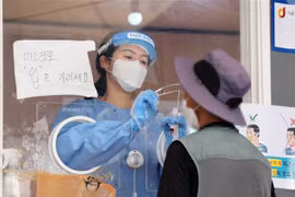 Nhân viên y tế lấy mẫu xét nghiệm COVID-19 cho người dân tại Seoul, Hàn Quốc. (Ảnh: YONHAP/TTXVN)