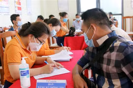Nhân viên y tế Bệnh viện Đa khoa tỉnh Lạng Sơn hướng dẫn nhân viên, lái xe làm việc tại Cửa khẩu Tân Thanh khai báo trước khi tiêm vắc xin COVID-19. (Ảnh: Thái Thuần/TTXVN)