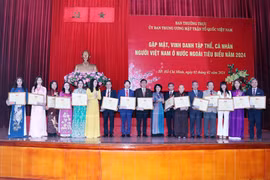 Trao tặng Bằng khen của Ủy ban Trung ương Mặt trận Tổ quốc Việt Nam cho các cá nhân kiều bào tiêu biểu. (Ảnh: Xuân Khu/TTXVN)