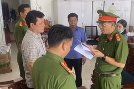 Cơ quan Cảnh sát điều tra, Công an tỉnh Cà Mau tống đạt quyết định khởi tố bị can và lệnh khám xét nơi ở, nơi làm việc của bị can Đặng Quốc Việt để điều tra về hành vi mua bán hóa đơn trái phép. (Ảnh: TTXVN phát)