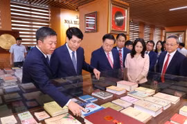 Thường trực Ban Bí thư Lương Cường, Trưởng Ban Tuyên giáo Trung ương Nguyễn Trọng Nghĩa với các đại biểu tham quan không gian sách của Nhà Xuất bản Chính trị Quốc gia Sự thật. (Ảnh: Văn Điệp/TTXVN)