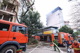 Lực lượng chức năng kịp thời khống chế ngọn lửa, không để cháy lan sang các hộ dân khác. (Ảnh: Tuấn Anh/TTXVN)