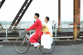 Hai bạn trẻ thướt tha, hạnh phúc trên cây cầu di sản Long Biên. (Ảnh: Quốc Khánh/ TTXVN)