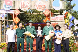 Hai anh em Nguyễn Tiến Thành và Nguyễn Tiến Đạt chụp ảnh lưu niệm cùng lãnh đạo huyện Phú Riềng và Ban Chỉ huy Quân sự huyện. (Ảnh: TTXVN phát)