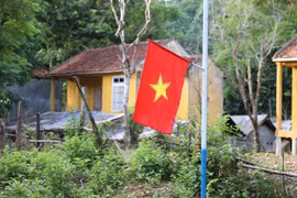 Cờ Tổ quốc được cắm tại bản tái định cư Văng Môn (xã Nga My, huyện Tương Dương, Nghệ An) của đồng bào dân tộc Ơ Đu. (Ảnh: Xuân Tiến/ TTXVN)