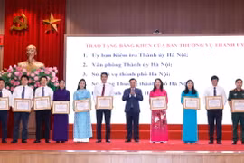 Bí thư Thành ủy Hà Nội Đinh Tiến Dũng trao tặng Bằng khen của Ban Thường vụ Thành uỷ cho các đơn vị có thành tích xuất sắc. (Ảnh: Doãn Tấn/TTXVN)