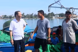 Thứ trưởng Bộ Nông nghiệp và Phát triển Nông thôn Phùng Đức Tiến (trái) trao đổi với ngư dân về tình hình khai thác hải sản trên biển. (Ảnh: Đoàn Hữu Trung/TTXVN)