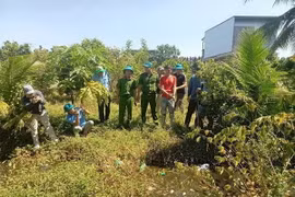 Công an tỉnh An Giang đưa đối tượng Thuận đi thu hồi tang vật vụ án. (Ảnh: TTXVN phát)