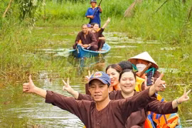 Du khách thích thú với hình thức đi xuyên rừng bằng xuồng ba lá tại điểm du lịch sinh thái ở vùng rừng U Minh hạ. (Ảnh: Huỳnh Anh/TTXVN)