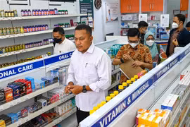 Cảnh sát và nhân viên y tế kiểm tra thuốc siro ho tại một cửa hàng thuốc ở Banda Aceh (Indonesia), ngày 24/10/2022. (Ảnh: AFP/TTXVN)