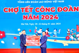 Ông Đinh Tiến Dũng, Ủy viên Bộ Chính trị, Bí thư Thành ủy Hà Nội trao biển tượng trưng kinh phí tặng quà Tết cho đoàn viên, người lao động. (Ảnh: Minh Nghĩa/TTXVN)