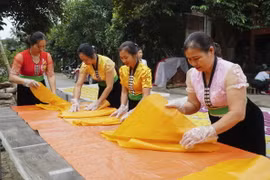 Bánh khẩu xén sau khi dát mỏng được mang đi phơi khô vừa phải rồi cắt. (Ảnh: Xuân Tư/TTXVN)