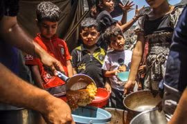 Các em nhỏ chờ được phát thực phẩm cứu trợ tại Jabalia, Dải Gaza ngày 8/6/2024. (Ảnh: THX/TTXVN)