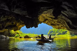 Các hang động được bao quanh bởi sông Ngô Đồng và những thảm lúa trải dài ven chân núi, đưa con người chìm đắm vào thiên nhiên. (Ảnh: Minh Đức/TTXVN)