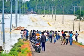 Nước lũ tràn qua một con đường ở quận Hojai, Assam (Ảnh: PTI)