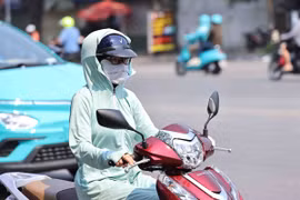 Người dân trang bị chống nắng khi ra đường. (Ảnh: Minh Đức/TTXVN)