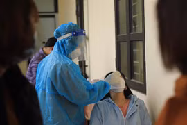 Nhân viên Trạm y tế lưu động số 1 xã Tân Triều, huyện Thanh Trì (Hà Nội) lấy mẫu xét nghiệm sàng lọc cho người dân trước khi hết cách ly, điều trị. (Ảnh: Hoàng Hiếu/TTXVN)