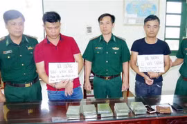 Hai đối tượng vận chuyển ma túy cùng tang vật bị Bộ đội Biên phòng Nam Định bắt giữ. (Ảnh: Văn Đạt/TTXVN phát)
