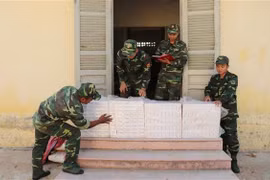 Cán bộ, chiến sỹ Đồn Biên phòng cửa khẩu quốc tế Tịnh Biên và Đội Đặc nhiệm thuộc Phòng Phòng chống ma túy và tội phạm (Bộ đội Biên phòng tỉnh An Giang) kiểm đếm tang vật vừa thu giữ. (Ảnh: Công Mạo/TTXVN)