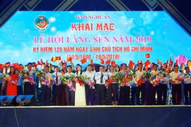 Tặng hoa cho các đoàn nghệ thuật tham gia biểu diễn tại đêm khai mạc Lễ hội Làng Sen năm 2019. (Ảnh: Tá Chuyên/TTXVN)