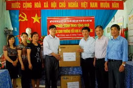 Ông Đỗ Cường, Phó Tổng Biên tập Báo Điện tử VietnamPlus, Chủ tịch Hội Cựu chiến binh - TTXVN trao tặng quà cho trường Tiểu học B Minh Tân. (Ảnh: Minh Tâm/Vietnam+)
