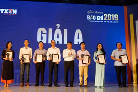 Tổng Giám đốc TTXVN Nguyễn Đức Lợi trao giải A cho các tác giả, đại diện nhóm tác giả đoạt giải. (Ảnh: Hoàng Hiếu/Vietnam+)