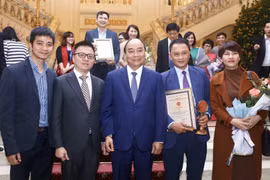 Thủ tướng Nguyễn Xuân Phúc với Phó Tổng giám đốc TTXVN Lê Quốc Minh và các tác giả đạt giải B (thể loại ảnh) thuộc Ban Biên tập Ảnh TTXVN. (Ảnh: Minh Quyết/TTXVN)
