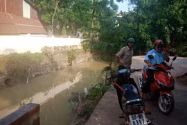Hiện trường nơi hai em học sinh bị tai nạn đường cong, tiếp giáp với suối và không có rào chắn. (Ảnh: Sỹ Tuyên/TTXVN)