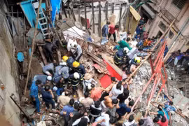 Lực lượng cứu hộ tìm kiếm nạn nhân bị mắc kẹt dưới đống đổ nát của tòa nhà bị sập ở Mumbai, Ấn Độ ngày 16/7. (Ảnh: India Today/TTXVN)