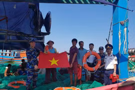 Tặng cờ Tổ quốc cho ngư dân. (Ảnh: Trần Tĩnh/TTXVN)