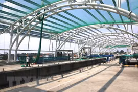 Công nhân lắp đặt lưới an toàn thi công hệ thống mái vòm nhà ga Khu công nghệ cao. (Ảnh: Hoàng Hải/TTXVN)