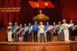 Tổng Bí thư, Chủ tịch nước Nguyễn Phú Trọng tặng hoa các đảng viên trẻ tiêu biểu. (Ảnh: Trí Dũng/TTXVN)