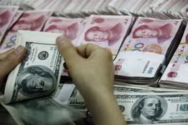 Kiểm đồng USD (phía trước) và đồng nhân dân tệ tại một ngân hàng ở Hoài Bắc, tỉnh An Huy, Trung Quốc. (Nguồn: AFP/TTXVN) 