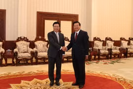 Thủ tướng Chính phủ Thongloun Sisoulith đón Phó Thủ tướng Phạm Bình Minh. (Ảnh: Phạm Kiên/TTXVN)