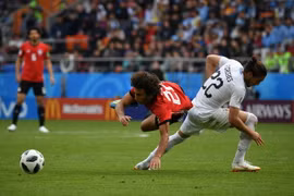 Pha tranh bóng quyết liệt giữa cầu thủ Amr Warda (trái) của Ai Cập và Martin Caceres của Uruguay trong trận đấu. (Nguồn: THX/TTXVN)