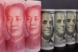 Đồng tiền giấy 100 nhân dân tệ (trái) và đồng USD ở Bắc Kinh. (Nguồn: Reuters/TTXVN)