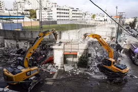 Máy xúc phá hủy một cửa hàng tại trại tị nạn Shuafat, Đông Jerusalem, ngày 21/11/2018. (Nguồn: AFP/TTXVN) 
