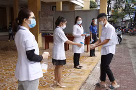Thí sinh rửa tay sát khuẩn phòng dịch COVID-19 trước khi vào phòng thi trong đợt một của kỳ thi. (Ảnh: PV/Vietnam+)