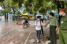 Thí sinh Hà Nội kết thúc buổi thi môn tổ hợp, được phát áo mưa khi rời trường thi. (Ảnh: PV)