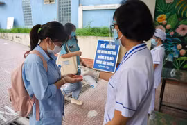 Thí sinh rửa tay sát khuẩn trước khi vào điểm thi thi. (Ảnh: PV/Vietnam+)