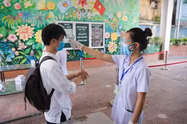 Thí sinh Hà Nội được đo thân nhiệt trước khi vào điểm thi. (Ảnh: Minh Sơn/Vietnam+)