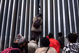 Người di cư Trung Mỹ trèo qua bức tường biên giới Mỹ-Mexico tại Playas de Tijuana, bang Baja California, Mexico, ngày 21/3/2019. (Nguồn: AFP/TTXVN)