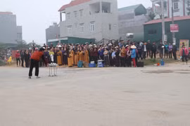 Người dân thôn Trung Nguyên, xã Trung Nguyên tập trung tại nơi xảy ra tai nạn vụ xe khách lao vào đoàn người đưa tang để làm lễ, cầu nguyện... (Ảnh: Nguyễn Trọng Lịch/TTXVN)